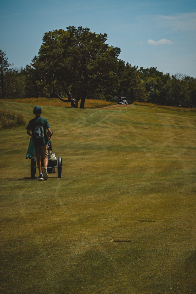 Caddie walking with clubs